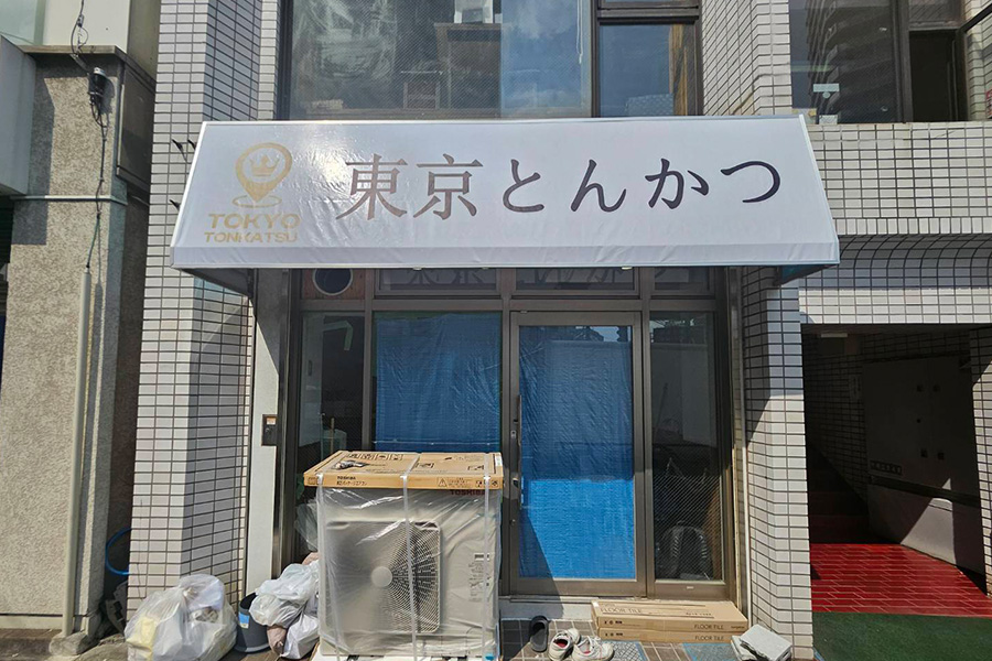 とんかつ屋さんの店名が書かれた白い看板
