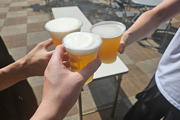 コップに入ったビールで乾杯する様子