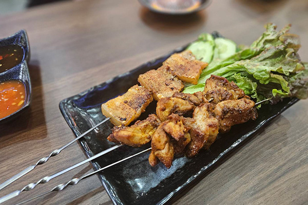 黒い皿の上に置かれた串焼き