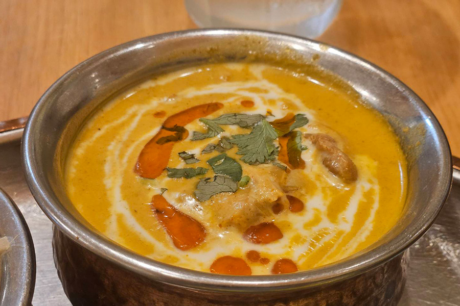 銀の皿に入った黄色のケララ風チキンカレー