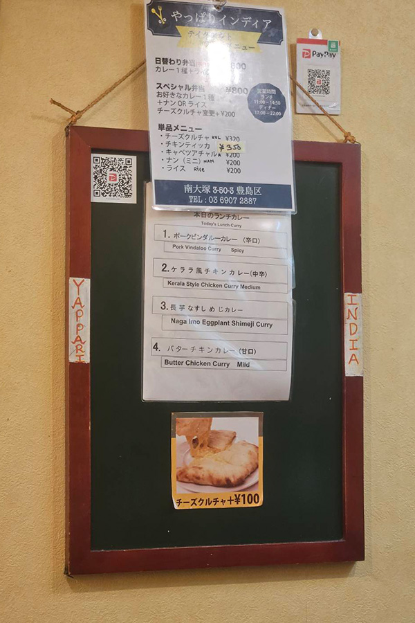 カレー屋さんのメニューが書かれた紙が貼られている掲示板