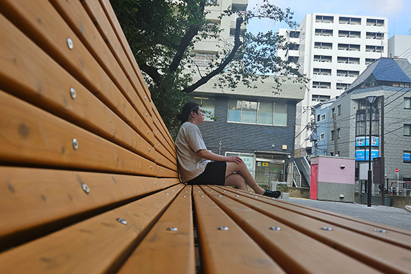 ベンチに座って景色を眺める男性