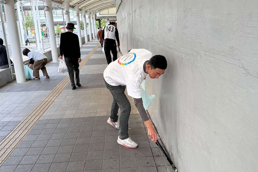 白いTシャツを着て街のゴミ拾いをする人々