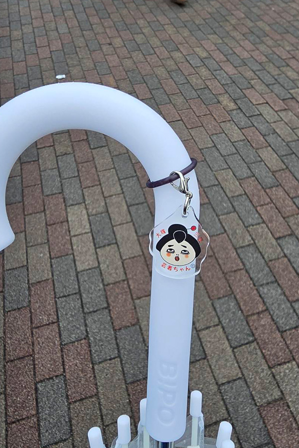 白い傘にセットされたゆるキャラの顔がプリントされたアンブレラマーカー