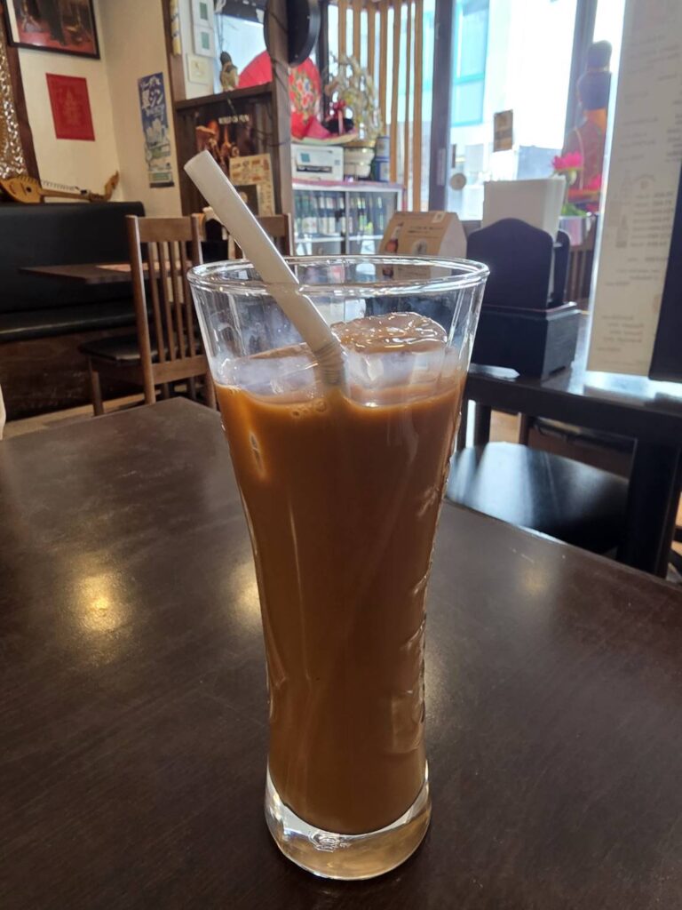 長いグラスに入った茶色い飲み物と白いストロー