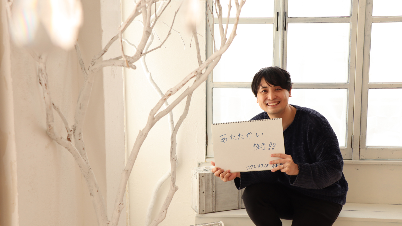 スケッチブックを持つ小暮さん。