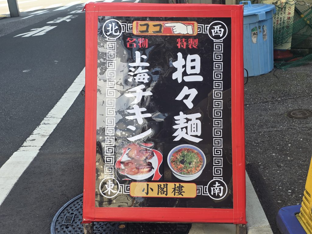 中華料理にイラストと名前が書かれた赤い縁の看板